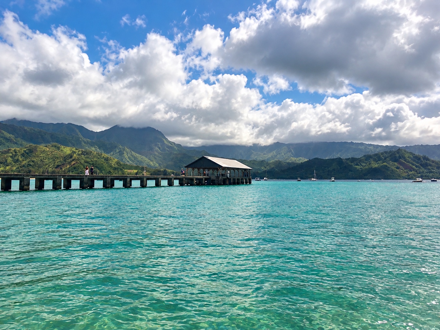Turquoise water and overwater accommodation beneath green mountains