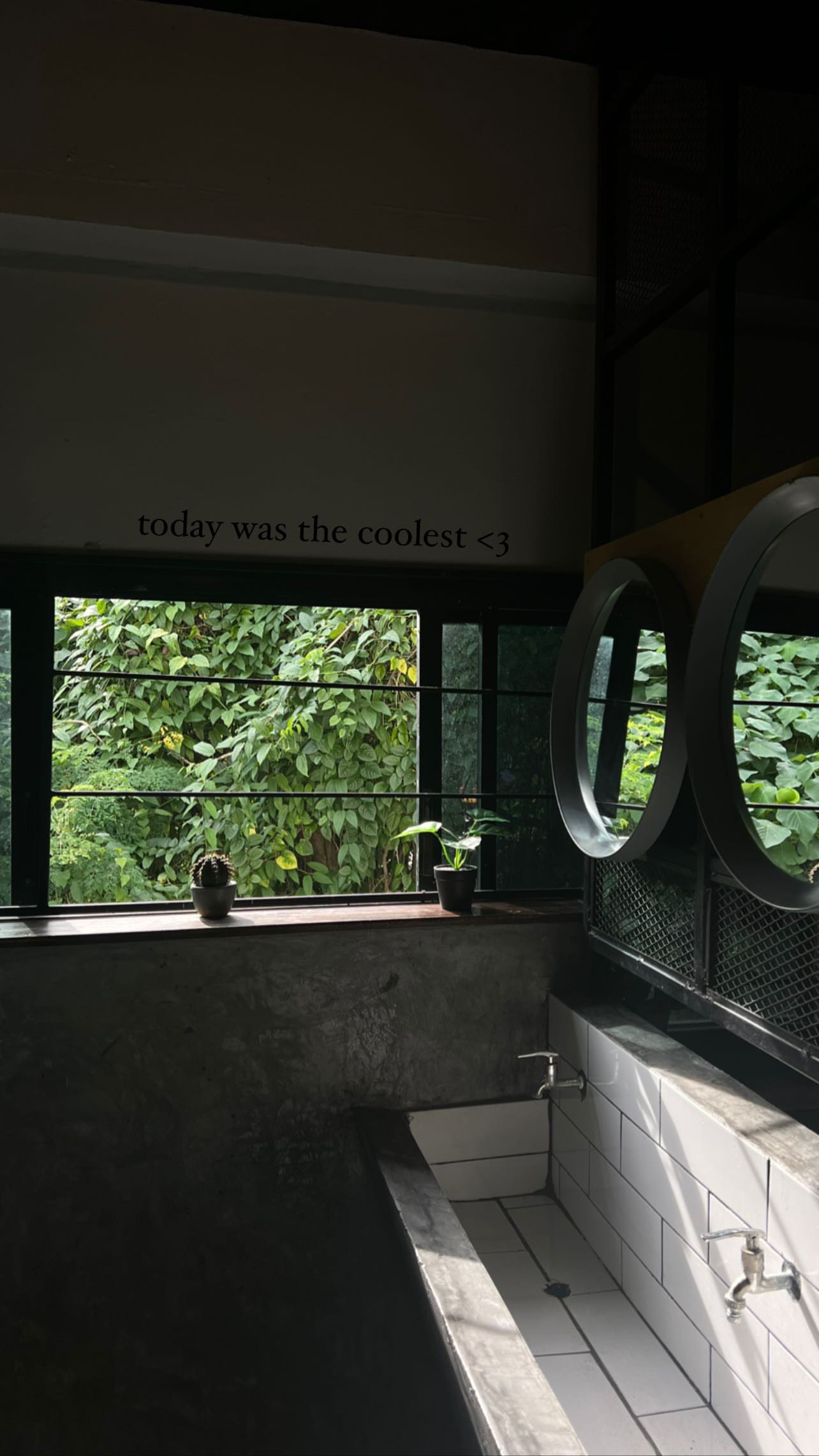 A quiet tiled interior with a window opening onto lush greenery