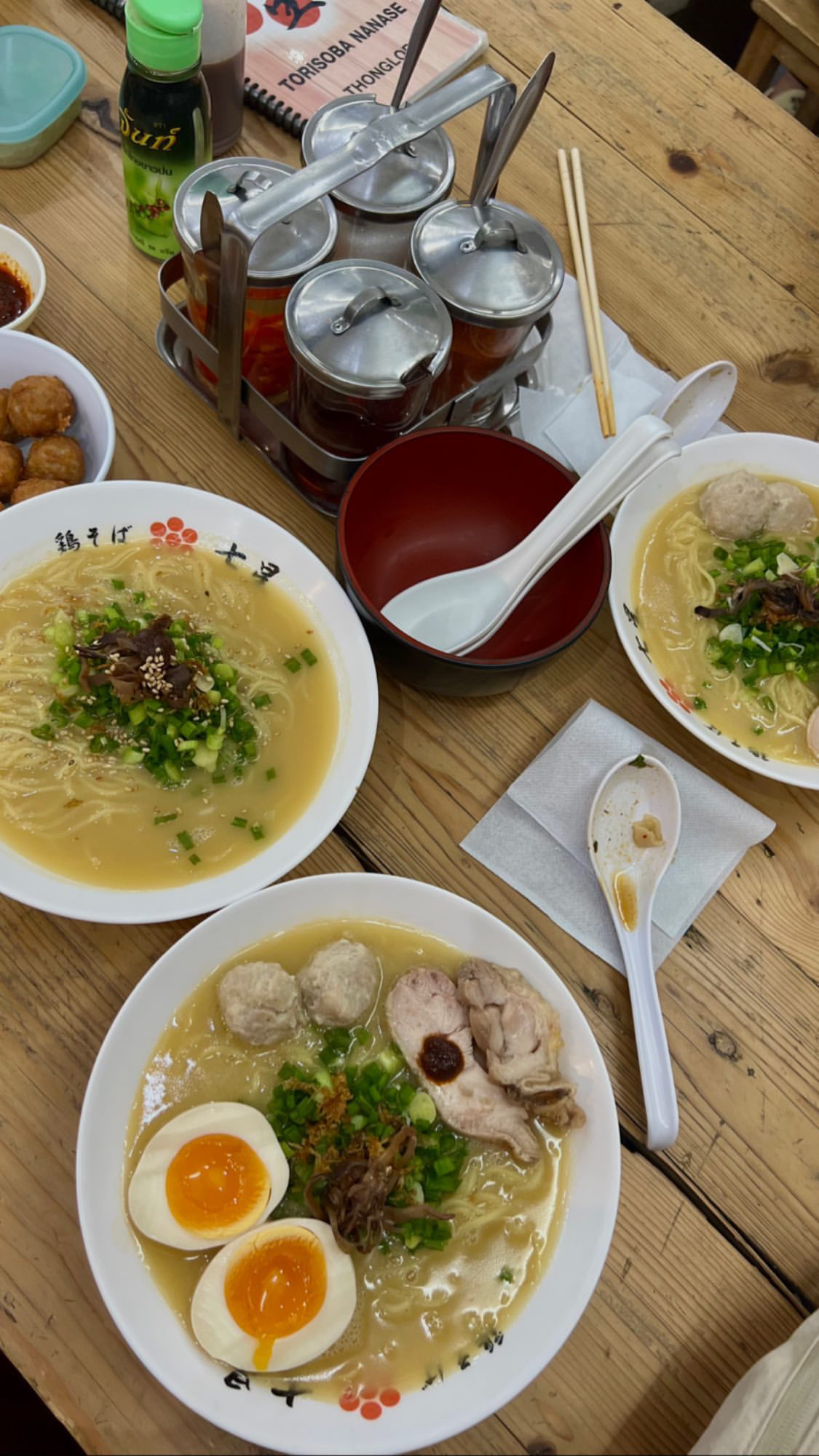 Bowls of noodles and drinks shared across a restaurant table