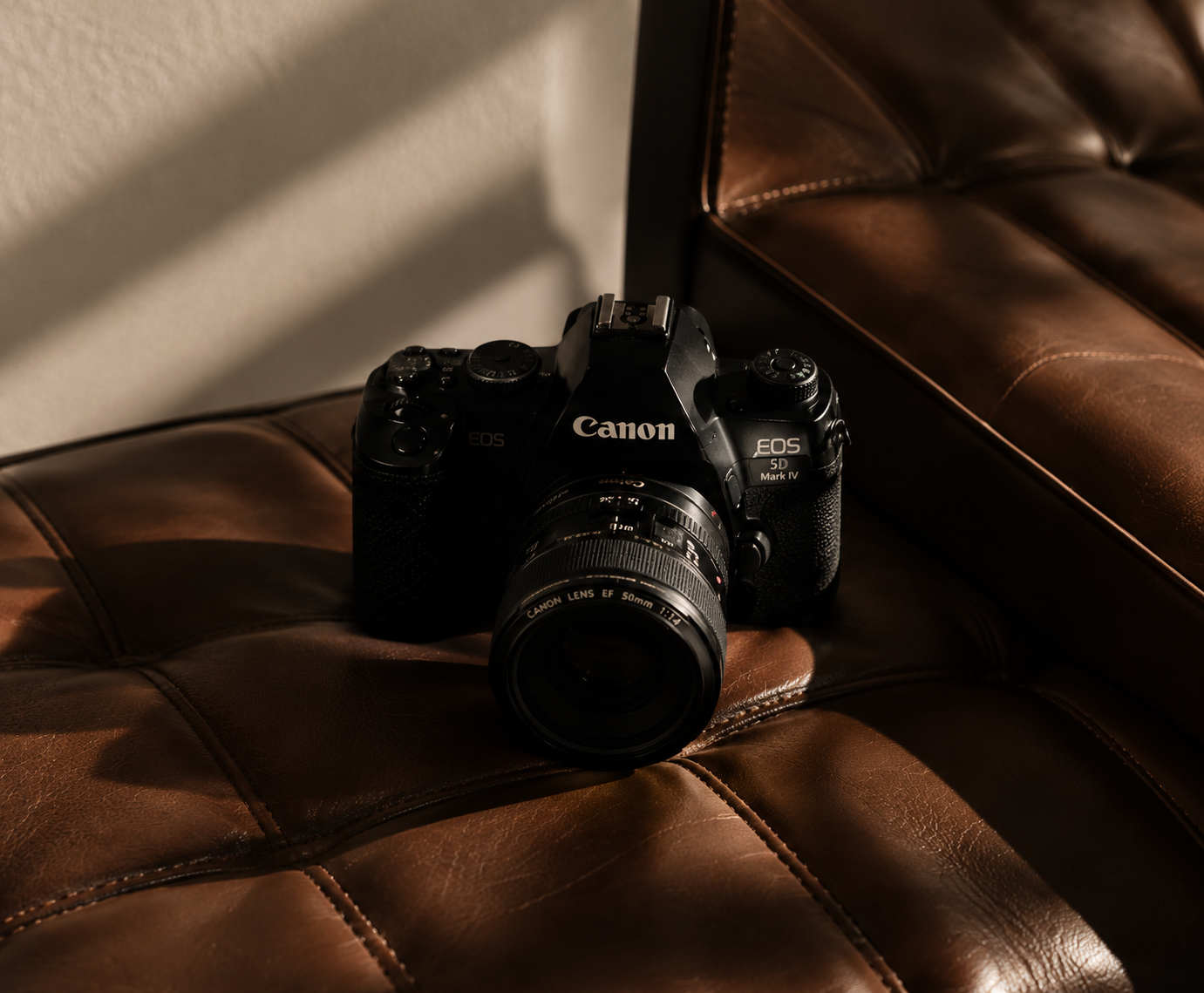 Canon camera and lens on brown leather seating